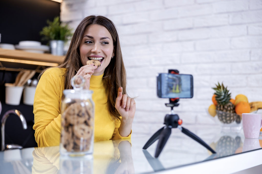 Micro-influencer eating a cookie and filming herself.